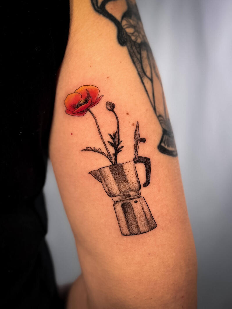 Moka con fiore rosso Tatuaggio surreale fine line di una moka stilizzata da cui nasce un fiore rosso aranciato, con dettagli puntinati e ombreggiature soft sul braccio